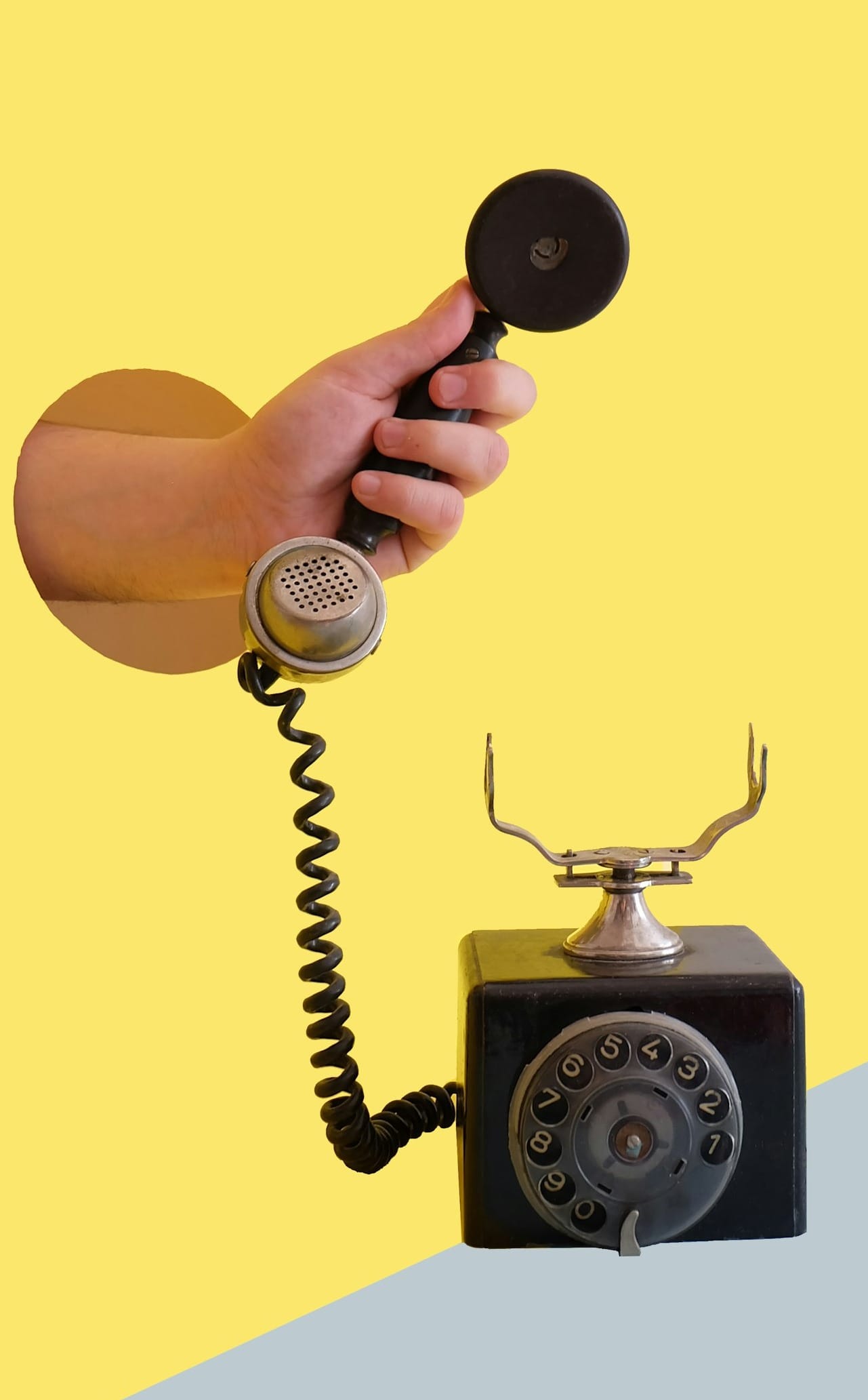 person holding black rotary telephone